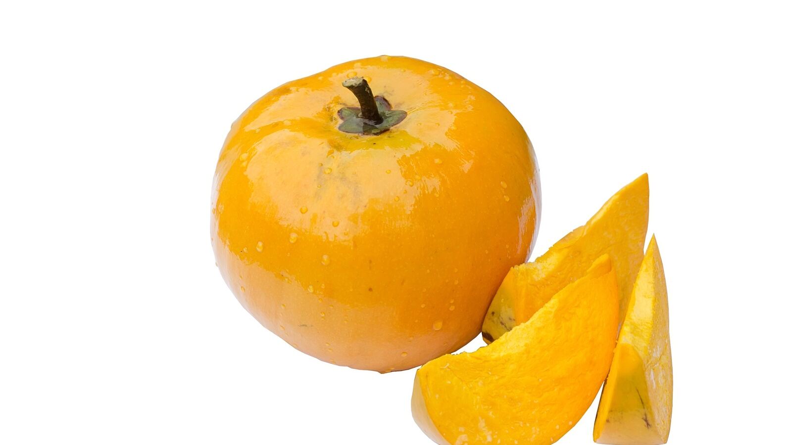 A bright orange canistel fruit cut to show its dense yellow flesh